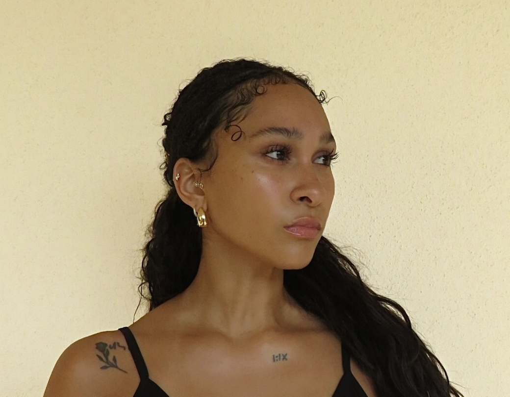 Maria Williams in three-quarter profile looking to the side against a warm cream wall