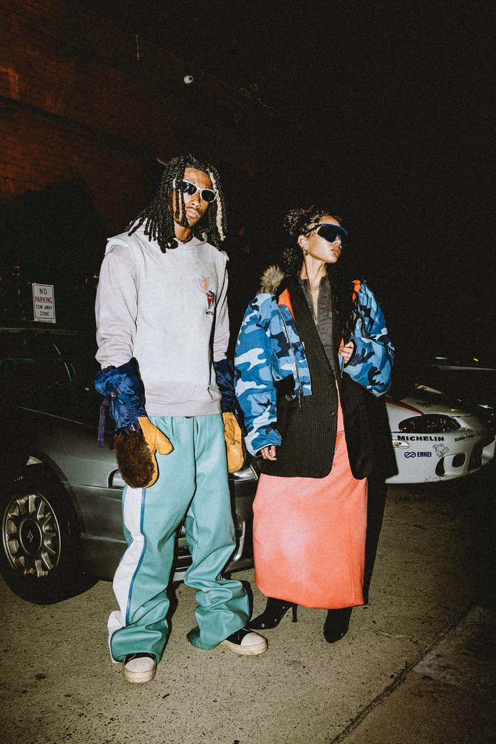 Maria Williams and a fellow model in Lab 74 looks beside parked cars at night